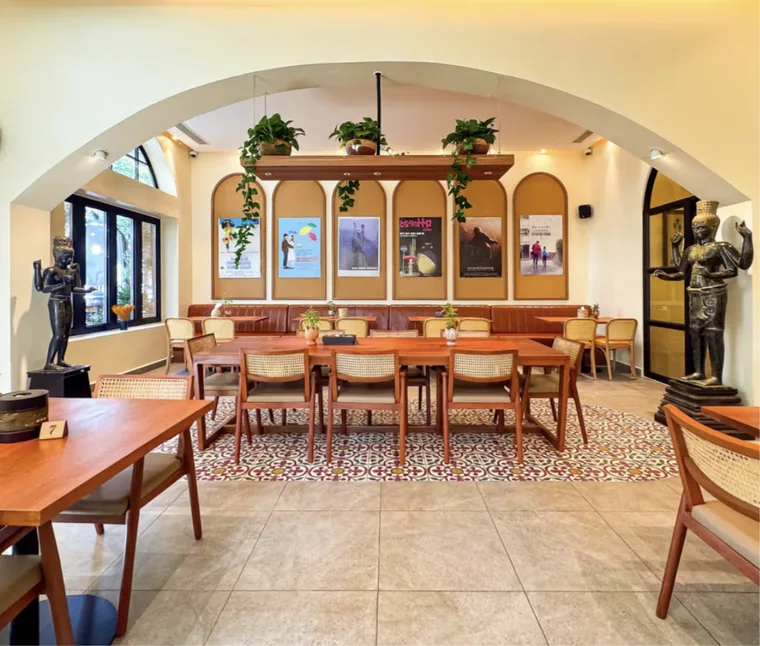 Bright café dining room with arched walls and film posters
